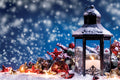 Decorative lantern with candles on a snowy surface with a festive background