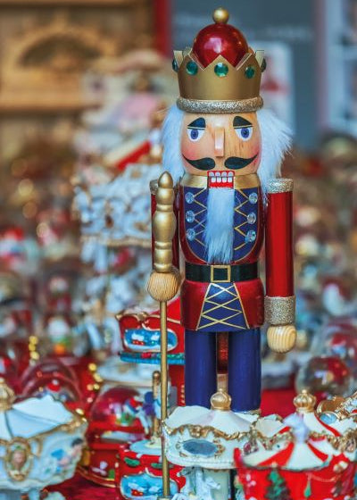 Decorative nutcracker figure with a crown, standing among other Christmas decorations.