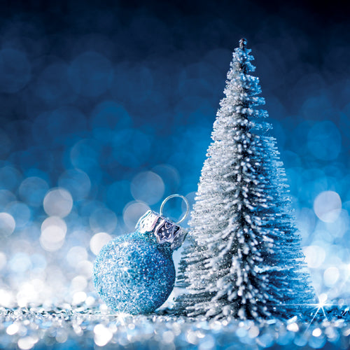 Blue Christmas ornament and miniature tree against a blurred blue background