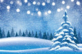 Snowy landscape with a Christmas tree and string lights