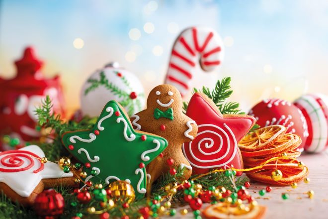 Decorative Christmas cookies with colorful icing on a festive background