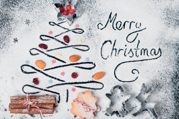 Decorative Christmas tree made of cookies and spices with 'Merry Christmas' text on a snowy background.