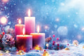 Decorative scene with candles and winter elements on a snowy background