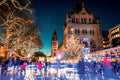 Ice skating rink in front of a large building with Christmas lights