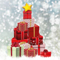 Stack of red gift boxes with a star on top against a silver glittery background