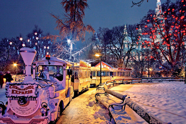 Snow-covered train in a park with festive lights and snow-laden trees at night.