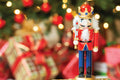 Nutcracker figurine with a festive background of lights and wrapped gifts